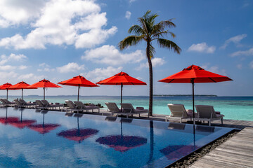 Luxurious resort in the Maldives with swimming pool and parasols and sun loungers