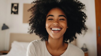 "Woman with curly hair smiling widely."