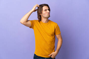 Fototapeta premium Young handsome man isolated on purple background having doubts while scratching head