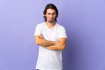 Young handsome man isolated on purple background with unhappy expression