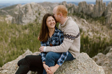Couple shares a joyful embrace atop a scenic Black Hills overlook