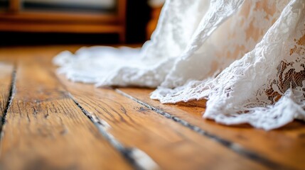 The hem of a lace dress on a wooden floor. 
