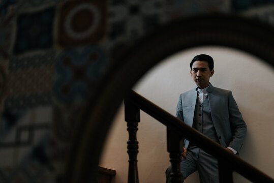 Young Man Looking in a Mirror on a Staircase