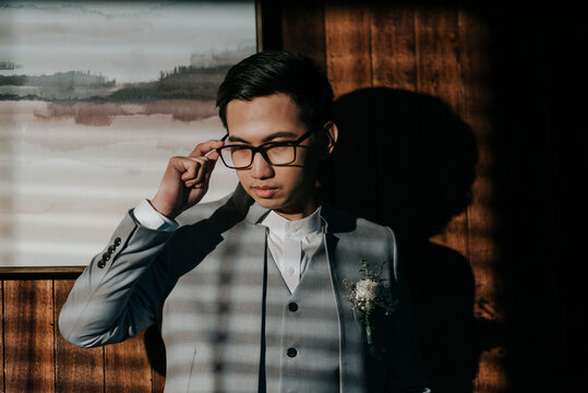A young man holding glasses