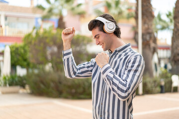Obraz premium Young handsome man listening music and dancing