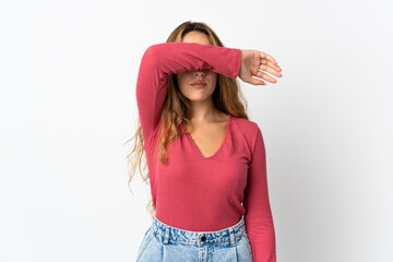 Young blonde woman isolated on blue background covering eyes by hands
