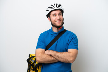 Young caucasian man with thermal backpack isolated on white background looking up while smiling