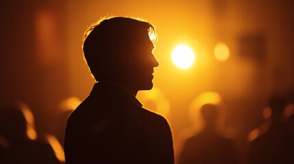 Silhouette of a Man Against a Warm Glowing Background of Light