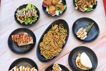 A table with many different types of Asian food on it