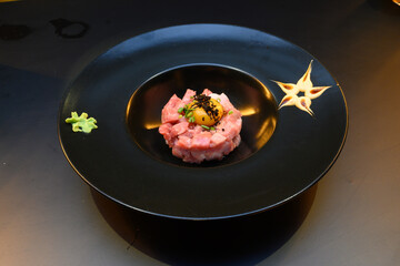 A black plate with a meat and egg dish