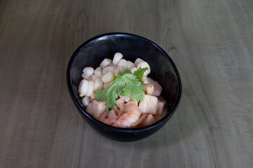 A bowl of food with shrimp and corn