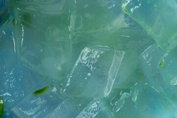 Freshly extracted aloe vera gel in a blue-green bowl. Background texture.