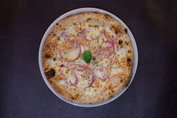 A pizza with onions and cheese on top