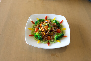A plate of food with broccoli and kiwi on it