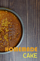 Homemade cake with pine nuts and chocolate. Rustic wood background, overhead view and text.