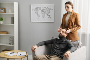 Psychologist working with patient during hypnosis session indoors