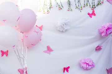 Decorative setup for a pink-themed celebration with balloons and flowers