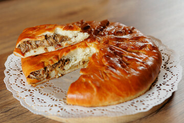 A delicious, flavorful meat pastry, adorned with a golden, crispy crust and elegantly placed on a decorative doily