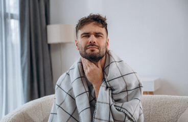 Pain in the throat. Sick man is feeling bad at home