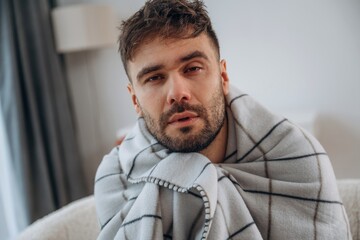 Fototapeta premium Tired, unhappy facial expression. Sick man is feeling bad at home