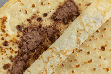 A close-up of a crêpe sprinkled with cocoa powder.