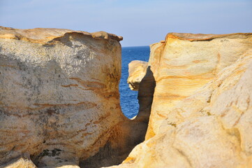The coast of red stones on the Barents Sea, patterns on the rocks.