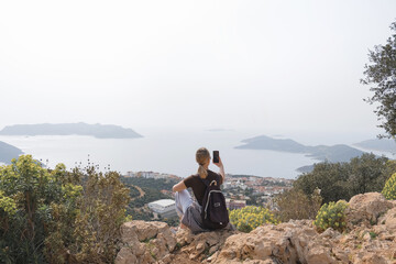 Naklejka premium Travel.solo traveler sits peacefully atop a mountain, embracing mindfulness amidst breathtaking natural beauty. eco-travel, self-care, and the rejuvenating power of nature