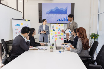 Group of business people working together with dashboard analysis and data management a meeting table in an office.
