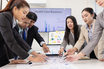Group of business people working together with dashboard analysis and data management a meeting table in an office.