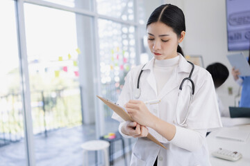 Female doctor with clipboard and standing at doctor's office in hospital, Healthcare and medical concept.