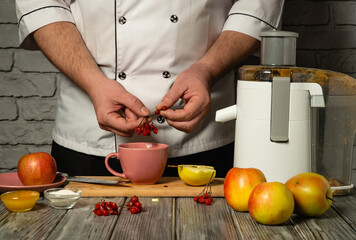 A skilled chef meticulously prepares fresh juice using vibrant apples and berries. The warm kitchen...