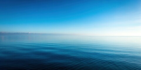 Obraz premium Minimalist Foggy Seascape: Calm Ocean Reflecting Blue Sky