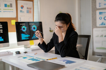 Stressed businesswoman suffering from headache and tired eyes after working on computer for too long