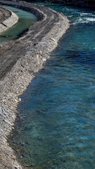 Scenic riverbank with clear blue water and curved path, nature, tranquility, outdoor landscape...