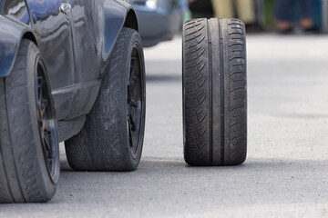 Naklejka premium New Car Drifting Tires and Worn-Out Tire in Service Pits. Drift race car in service area.
