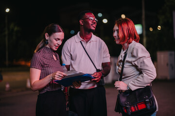 A diverse group of business people engaged in a strategic discussion late at night. They appear...