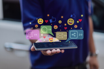 Hand holding a smartphone with floating social media notifications, including likes, messages, and...