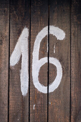 Number 16 on wooden surface. 16