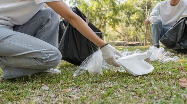 Close-up of a volunteer picking up trash, promoting a cleaner environment.
