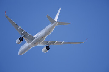 青空を背景に離陸して行く飛行機