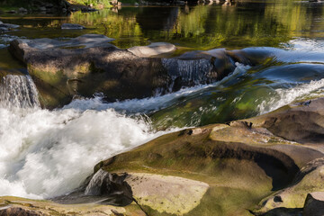 Water streams between the rocks at the beginning of waterfall