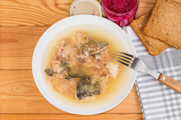 Jellied fish with horseradish sauce on rustic table, top view