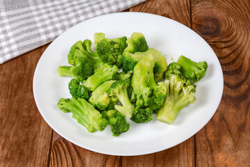 Pieces of boiled broccoli on dish on a rustic table