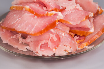 Chopped dry-cured pork loin on saucer, fragment close-up