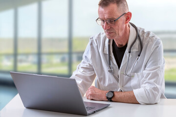 Doctor on laptop in modern clinic