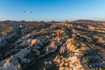 Nevsehir, Turkey. Colorful hot air balloon flying over Cappadocia, Turkey. Hot air balloons flying in sunrise sky. Goreme village in the distance