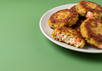 Golden Brown Crab Cakes on a Green Background