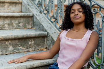 Fototapeta premium Young woman relaxing on ancient stairs with closed eyes