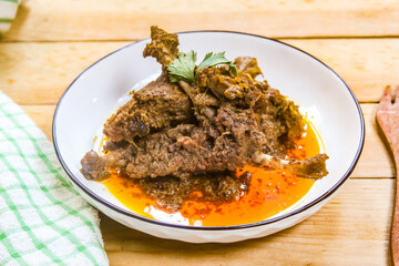 duck meat dish on a plate, cooked in a traditional way using spices and coconut.