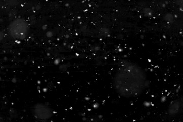 Texture of natural falling snow on black background.